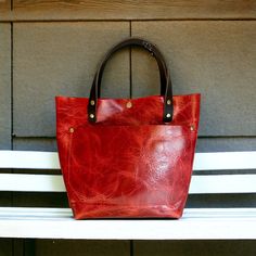 These beautiful totes are one of a kind timeless classics. They are all made with 100% genuine leather ranging from 3-5 oz. All exterior seams are double stitched. This adorable bag measures approx. 10 1/2" tall, approx. 12 1/2" across the top, approx. and has a depth of approx. 5".  The handles have an approx. drop of 7". You can pick to have handles or no handles, snap or no snap, handle color and fastener color. I do not include the cross-body strap.  I use real leather for all my items, whic Classic Red Satchel With Leather Handles, Burgundy Leather Shoulder Bag With Handles, Red Leather Bags For Errands, Red Rectangular Bag With Leather Lining, Red Rectangular Satchel With Leather Lining, Red Leather Satchel With Leather Lining, Red Top Handle Bag With Smooth Grain, Red Leather-lined Bag For Everyday Use, Red Leather Everyday Bag