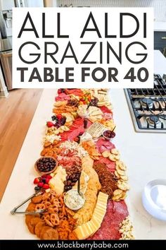 a long table covered in lots of different types of food and the words, all aldi graziing table for 40