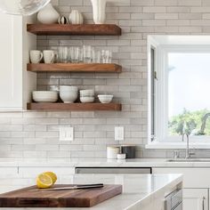 a kitchen with white cabinets and open shelves