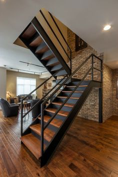 an open living room with wood floors and stairs