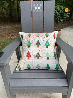 a chair with a pillow sitting on top of it next to a wooden fence and trees