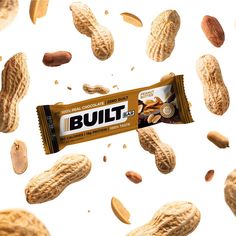 the peanut butter bar is flying through the air with peanuts scattered around it on a white background