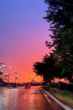 cars driving down the road at sunset