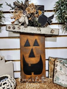 a wooden sign with a jack - o'- lantern face on it sitting next to other items