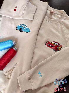 the shirt has cars on it and is next to scissors