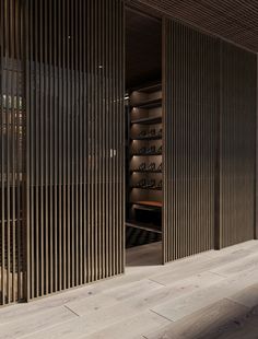 an empty room with wooden slats on the walls, and a bench in front of it