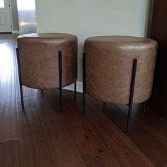 two brown stools sitting on top of a hard wood floor