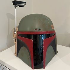 a boba fett helmet is on display in a room with white walls and cabinets