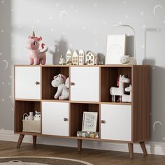 a white and brown bookcase with toys on it in a child's room