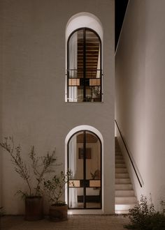 a white building with an open window and stairs leading up to the second floor area