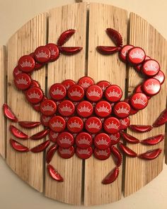 a red crab made out of buttons on a wooden board