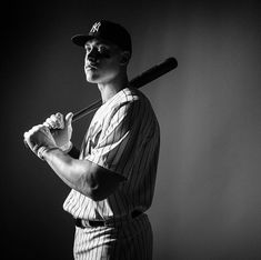 a black and white photo of a baseball player holding a bat in his hands,