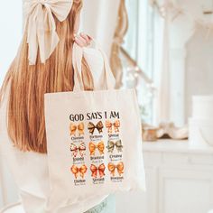 a woman holding a bag with the words god says i am