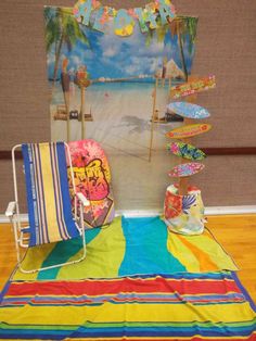 a beach towel and chair are sitting on the floor in front of a wall with pictures