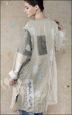 a woman standing in front of a wall with her back turned to the camera and looking down