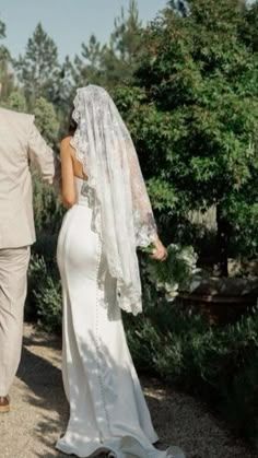 a bride and groom walking down a path