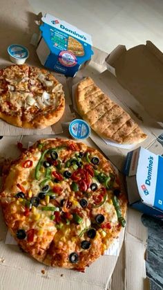 three different pizzas sitting on top of cardboard boxes