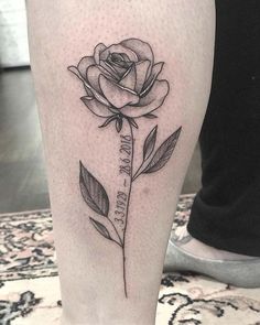 a black and white rose tattoo on the leg