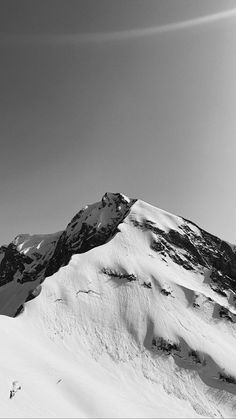 a person on skis is standing in front of a snow covered mountain with a sky background