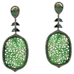 Gorgeous oval-shaped carved jade dangle earrings with emerald and spinel accents and shimmering diamonds. 18k:1.71g, Diamond:3.5ct, Silver:20.65gm, Emerald:0.7ct, Jade-41.85, Spinel-4.10 Size: 90X36MM" Gemstones Earrings, Gold Fashion Jewelry, Amazing Earrings, Black Earrings Dangle, Carved Jade, Jewelry Sterling Silver, Black Spinel, Emerald Jewelry, Earrings Black