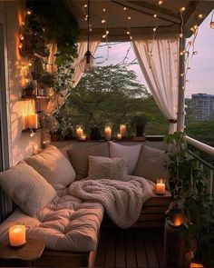 a couch sitting on top of a wooden floor next to a window filled with candles