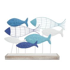 a group of blue and white fish sitting on top of a wooden stand next to each other