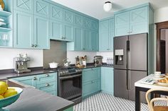 a kitchen with teal cabinets and black counter tops is pictured in this image from the front view