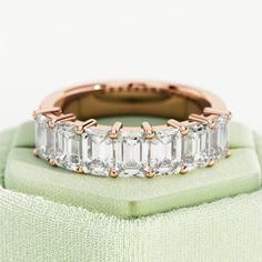 a diamond ring sitting on top of a green velvet baguette cushioned pillow