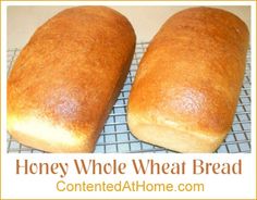 two loaves of bread sitting on top of a cooling rack with the words honey whole wheat bread