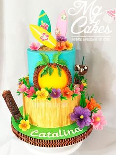 there is a cake decorated with surfboards and flowers