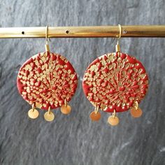 I make these Boho earrings of polymer clay in a coral colour, mika powder, gold plated brass hooks, discs and jump rings. I stamped a gold floral relief into the clay to bring the surface to life. The coral earrings are super leightweight and won't pull your earlobes down. Standard delivery without tracking is already included. For tracking, please go for an upgrade during check-out. I strongly advise my international customers to purchase the shipping upgrade during check-out which will be a tr Handmade Red Flower Earrings For Festive Occasions, Handmade Red Polymer Clay Earrings, Red Drop Earrings In Polymer Clay, Handmade Polymer Clay Flower Earrings In Gold, Handmade Gold Polymer Clay Flower Earrings, Handmade Gold Flower Earrings In Polymer Clay, Festive Red Brass Earrings, Red Polymer Clay Dangle Jewelry, Red Polymer Clay Earrings