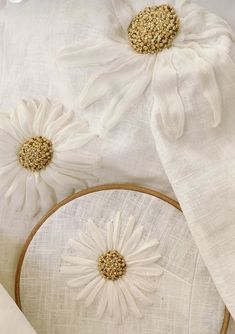 two white flowers are sitting on top of some linen