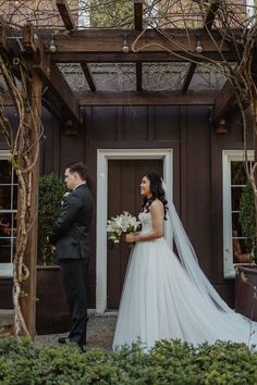 a bride and groom standing in front of a building