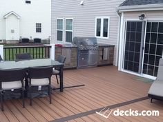 an outdoor deck with chairs and grill on it