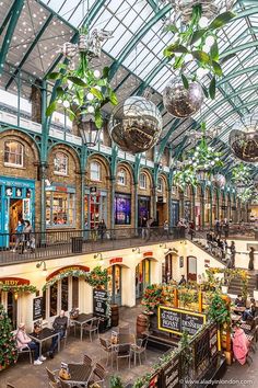 the inside of a shopping mall filled with lots of plants and hanging decorations on the ceiling