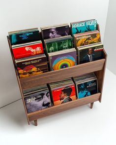 a wooden book shelf filled with books on top of white flooring next to a wall