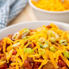 a white bowl filled with chili and cheese