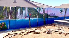 a mural on the side of a building in front of a pool and palm trees