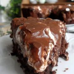 a piece of chocolate cake sitting on top of a white plate next to a fork