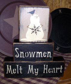 a snowman melts my heart sign sitting on top of a table next to a plate