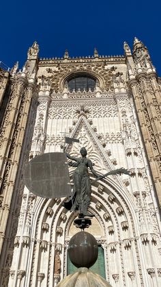 a statue on top of a ball in front of a building