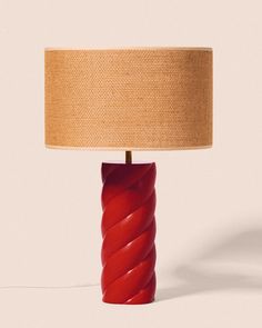 a red lamp with a beige shade on it