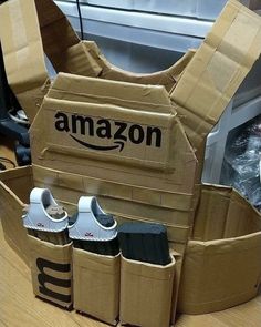 an open cardboard box with shoes in it and the amazon logo on its back, sitting on a table