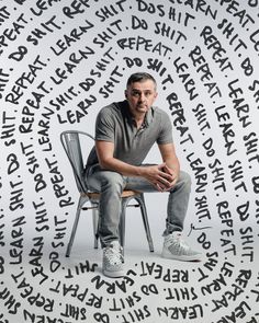 a man sitting on top of a chair surrounded by words