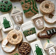 many decorated cookies are arranged in the shape of starbucks's coffee and donuts