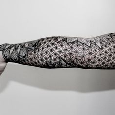 the arm is covered with black and white tattoos