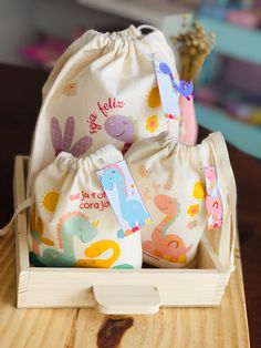 two drawstring bags sitting on top of a wooden table