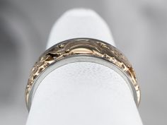 This band is very subtle, a combination of cut-outs and floral motifs. This vintage band dates to the mid-1900s and is well suited to a man or a woman. It's wider than many modern bands and engraved with a scrolling flower pattern. The quality of manufacture is very nice, and this will be a great piece for wearing alone or with an engagement ring. Metal: 14K Rose Gold, 18K White Gold Width of Band: 6.6 mm Height off Finger: 1.6 mm Ring Size: 5.50 Marks: "14-18K" Stamped on the inside band Formal Engraved Gold Bands, Formal Decorative Band Rings, Formal Gold Engraved Bands, Anniversary Engraved Band Ring, Formal Engraved Band Jewelry, Engraved Bands For Anniversary, Flower Wedding Band, Floral Filigree, Flower Band