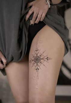 a woman's thigh with a tattoo design on the side and an arrow in the middle