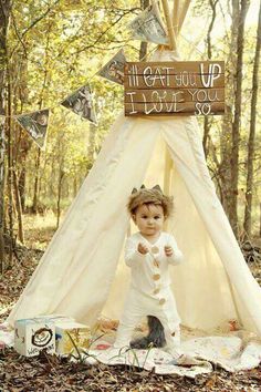 a small child is standing in front of a teepeet with the words i love you